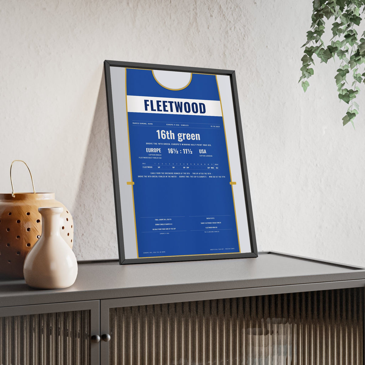 Tommy Fleetwood Rome 2023 Golf Poster - Caddie Bib Europe v USA Winning Point Print framed and leaning on a sideboard