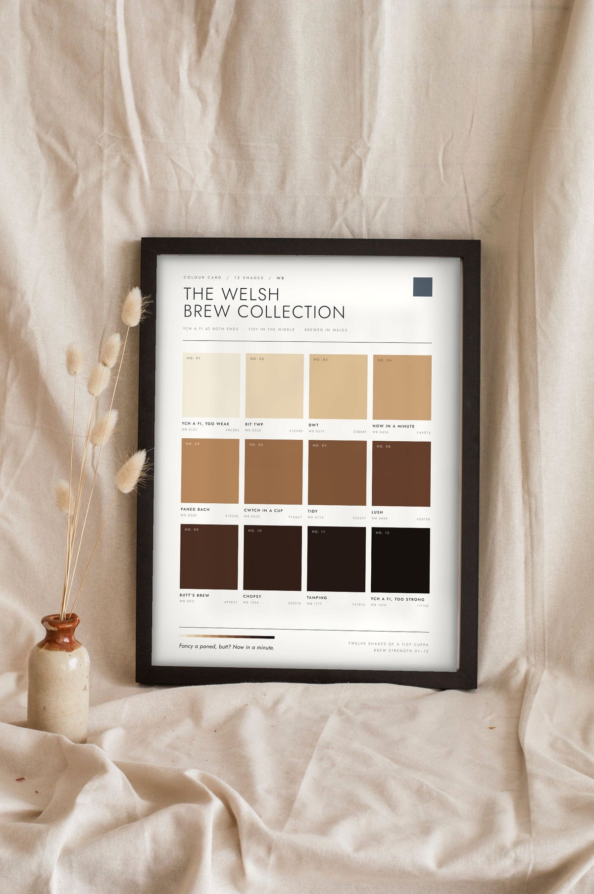 Welsh Brew Colour Chart in a black frame propped up on linen