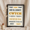 Welsh Slang Print in a black frame propped up on linen