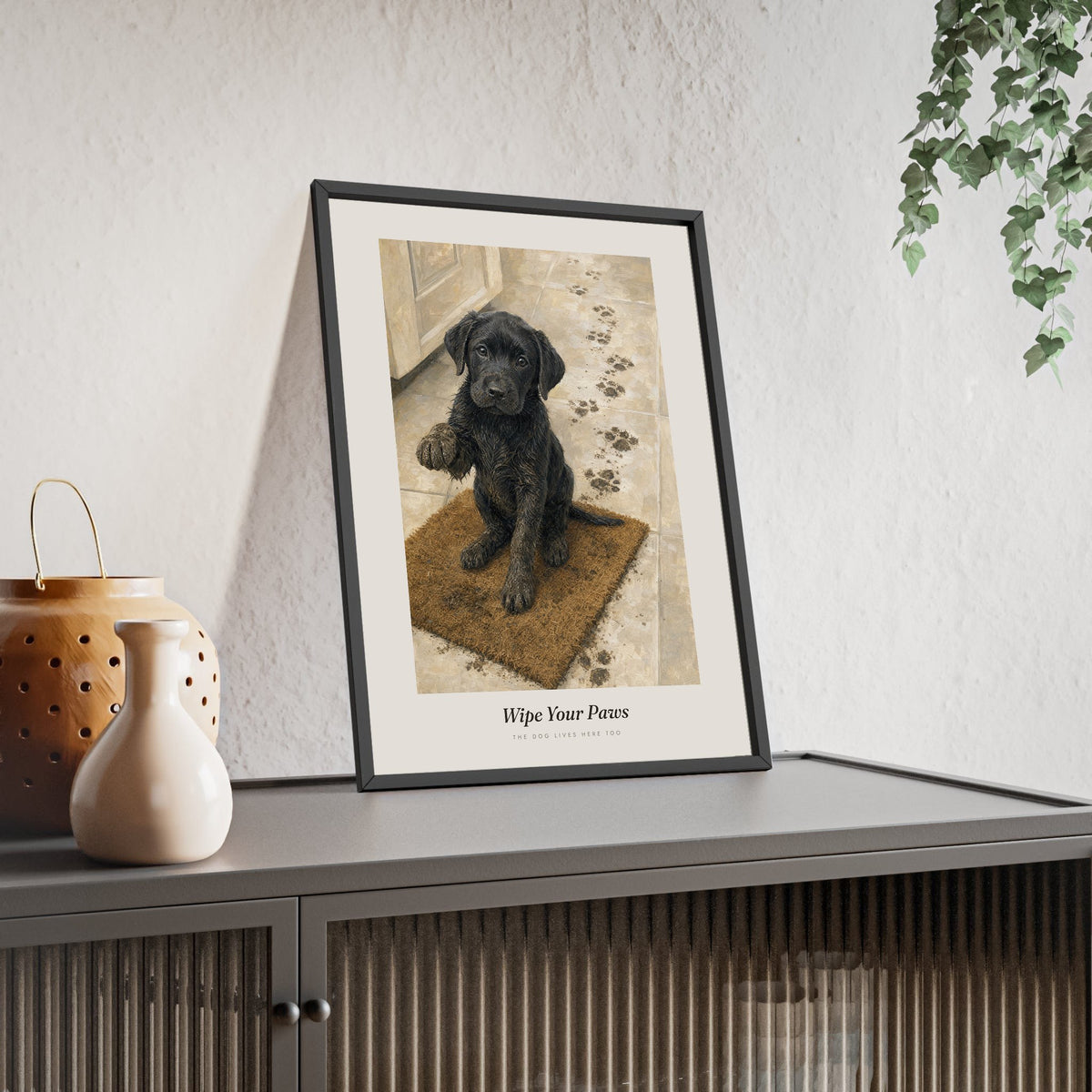 Wipe Your Paws Print framed and leaning on a sideboard