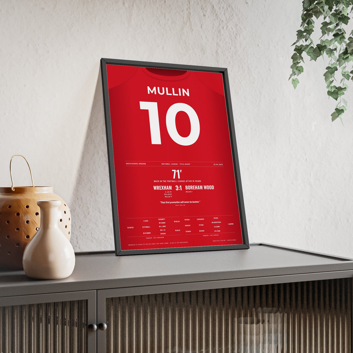 Wrexham Promotion 2023 Poster - Paul Mullin 10 Racecourse Ground framed and leaning on a sideboard